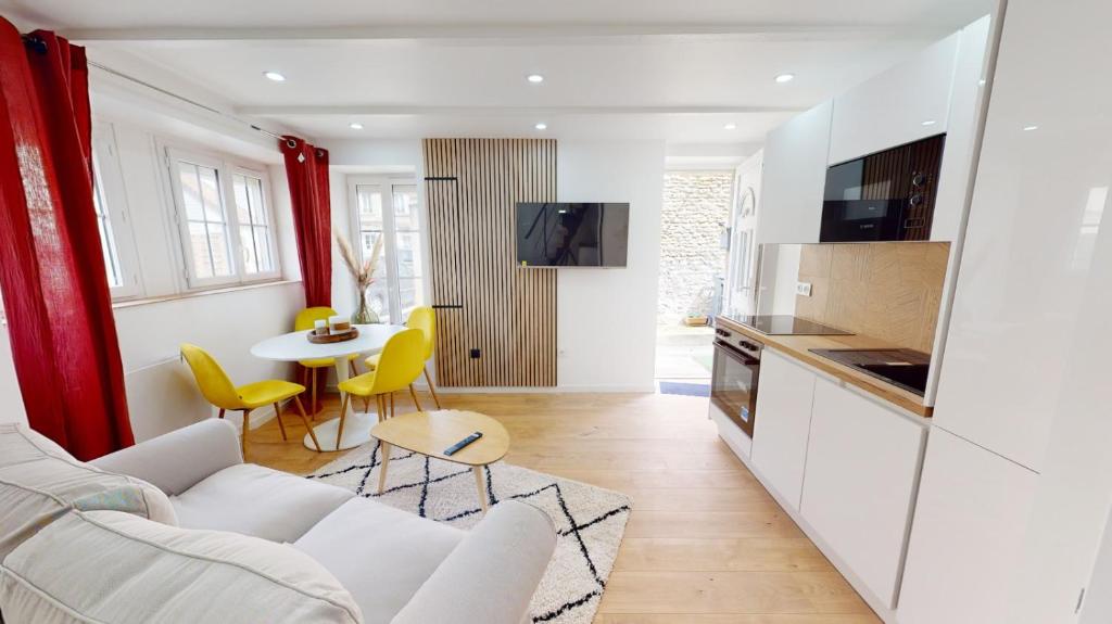 Salon lumineux ouvert sur la cuisine equipee de la Charmante Maison en Pierre a Ouistreham