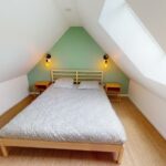 Chambre sous combles avec lit double et mur vert, Charmante Maison en Pierre a Ouistreham