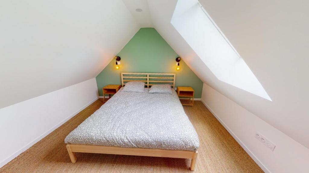 Chambre sous combles avec lit double et mur vert, Charmante Maison en Pierre a Ouistreham